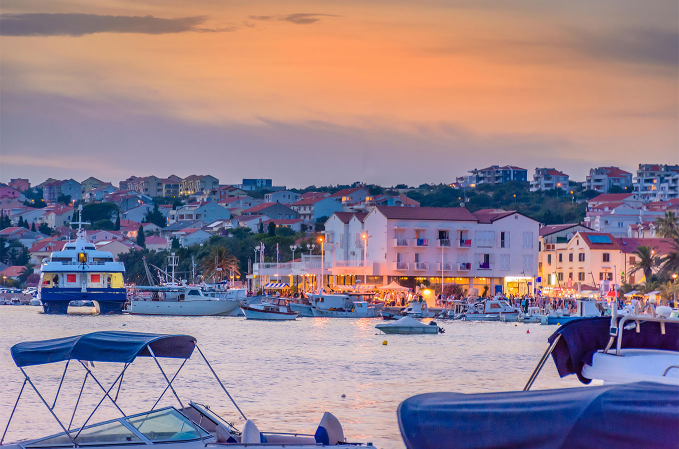Novalja harbour and waterfront at sunset, with boats in the bay